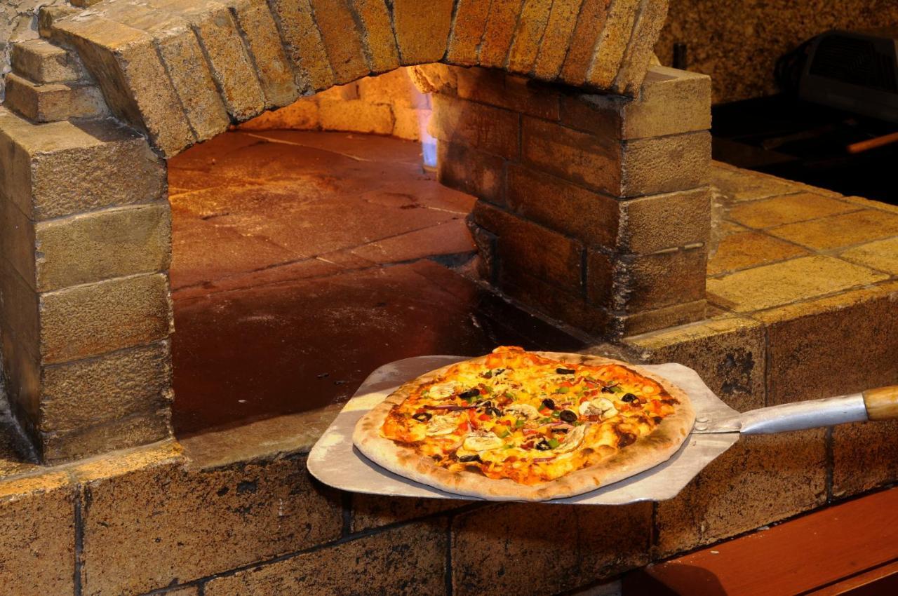 墨西哥城wtc贝莱尔独特酒店-温德姆商标精选 外观 照片 Pizza being removed from a wood-fired oven
